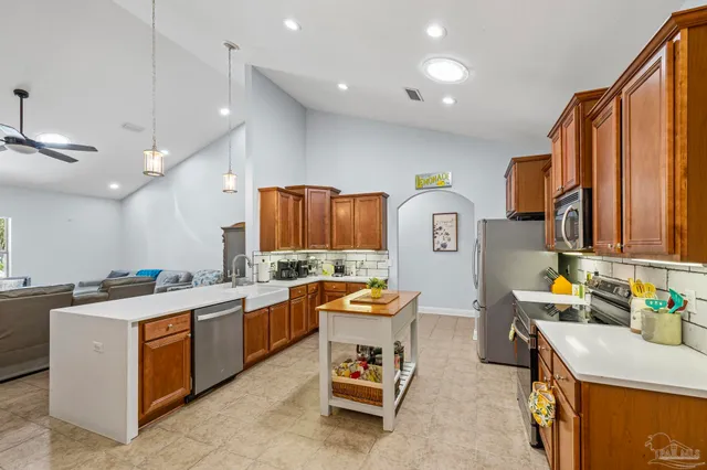 a large kitchen with a large counter top space appliances and a sink
