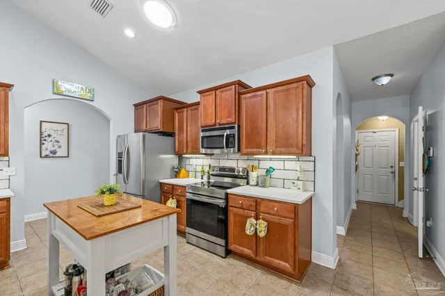 a room with stainless steel appliances kitchen island granite countertop furniture and a view of living room