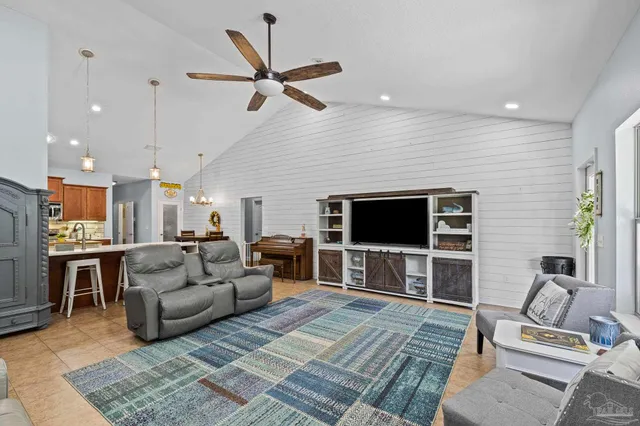 a bedroom with a bed a flat tv screen and a dresser