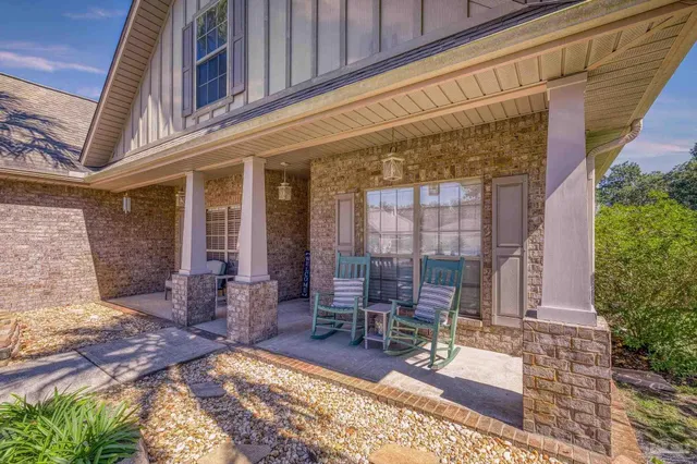 a view of swimming pool with lawn chairs under an umbrella