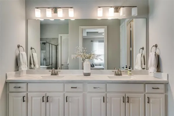 a bathroom with double vanity sinks and a mirror