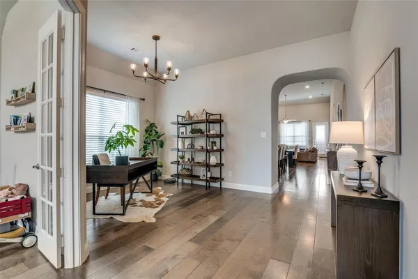 a view of a dining room and livingroom with furniture wooden floor a chandelier