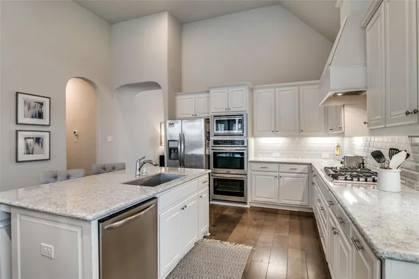a kitchen with stainless steel appliances granite countertop a sink stove and refrigerator