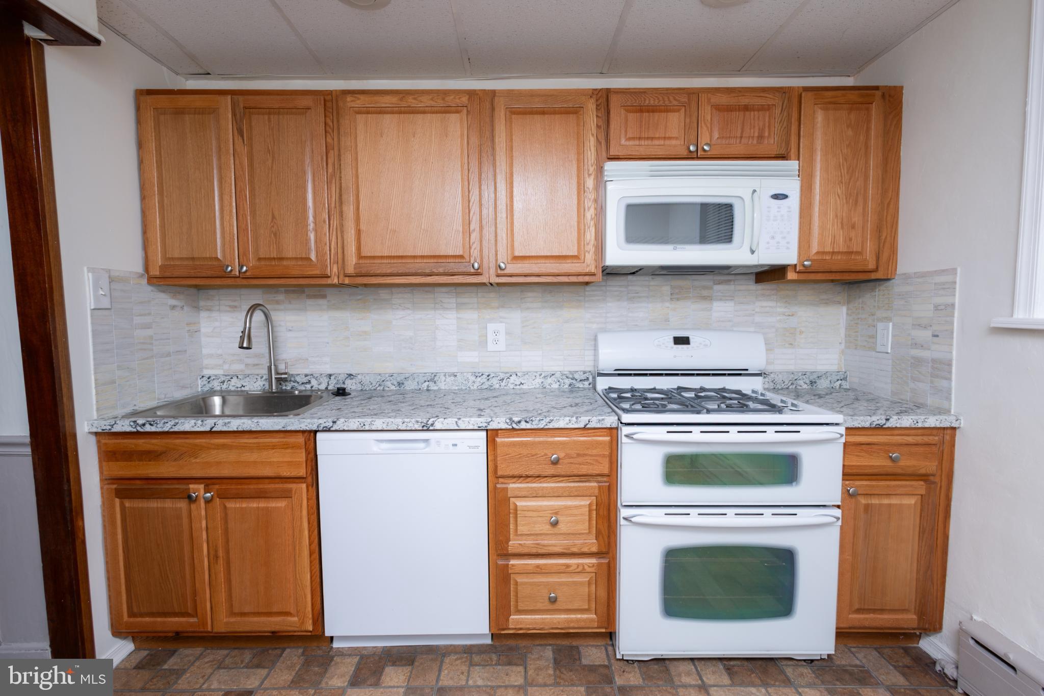 4243 Frost Street Philadelphia, PA 19136 - Photo 27 of 28 a kitchen with granite countertop wood cabinets and stainless steel appliances