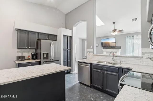 a kitchen with stainless steel appliances granite countertop a sink stove microwave and refrigerator