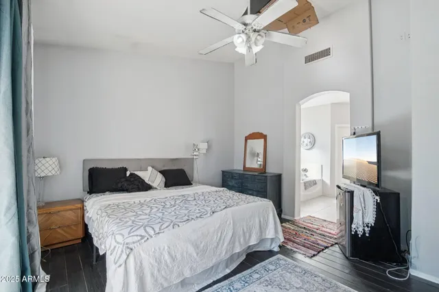 a bedroom with a bed and a mirror with a flat tv screen