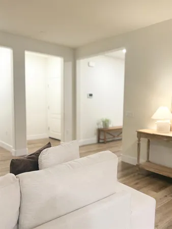a living room with a bed furniture and next to a window