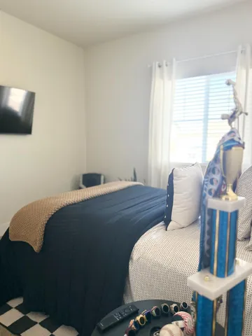 a bedroom with a bed and wooden floor