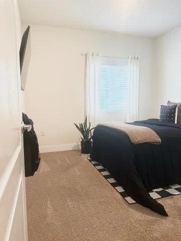 a bedroom with a bed and a painting on the wall