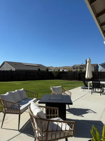a view of a patio with lawn chairs under an umbrella