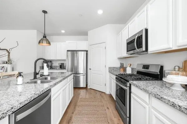 a kitchen with stainless steel appliances granite countertop a sink stove and refrigerator