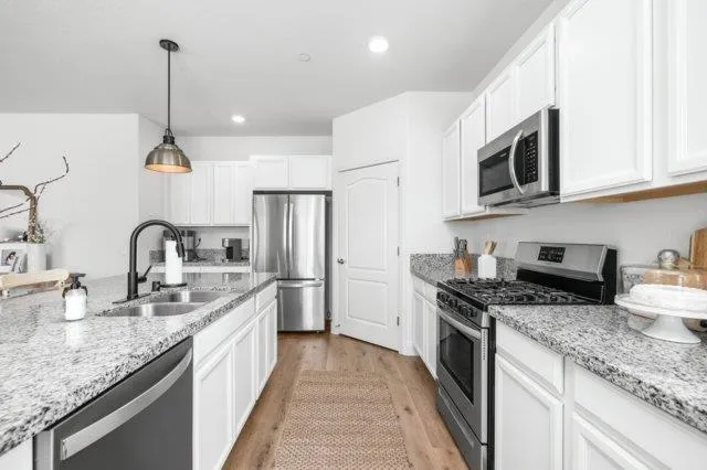 a kitchen with stainless steel appliances granite countertop a sink stove and refrigerator