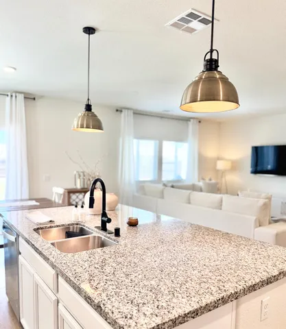 a kitchen with a sink a counter and wooden floor