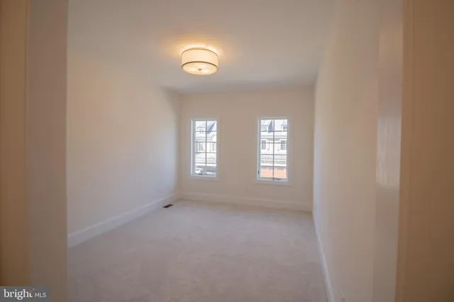 an empty room with an entryway and chandelier fan