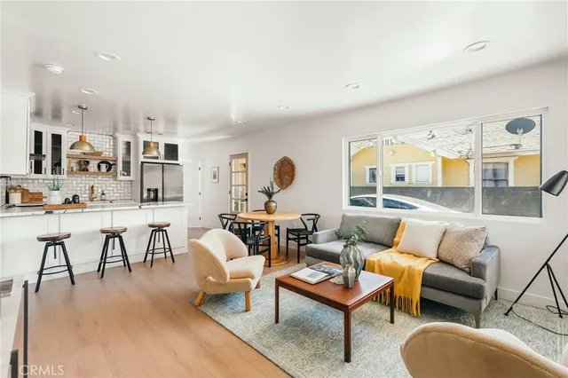 a living room with furniture wooden floor and a large window