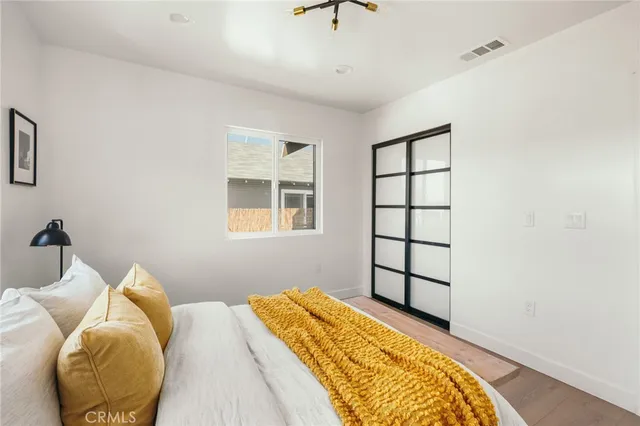 a bedroom with a bed and wooden floor