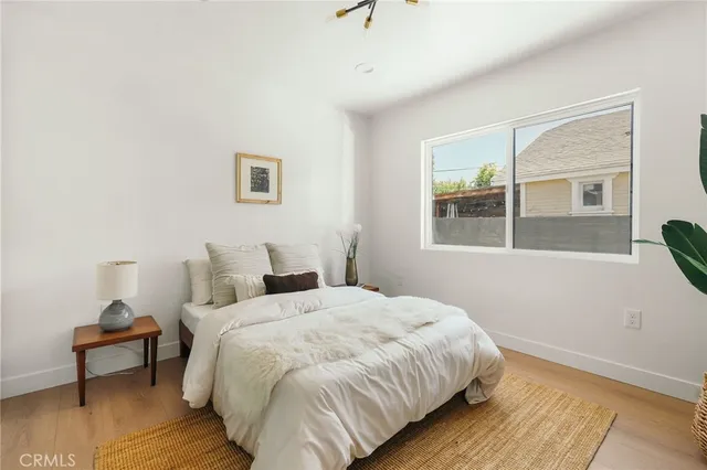 a kitchen with stainless steel appliances kitchen island granite countertop a stove a refrigerator a dining table and chairs with wooden floor