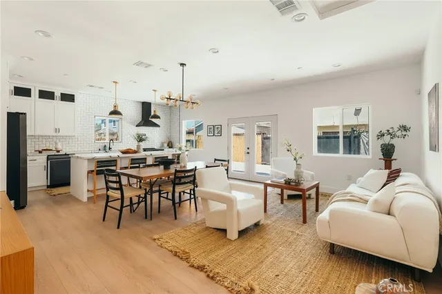 a large white kitchen with a sink a stove and a wooden floor