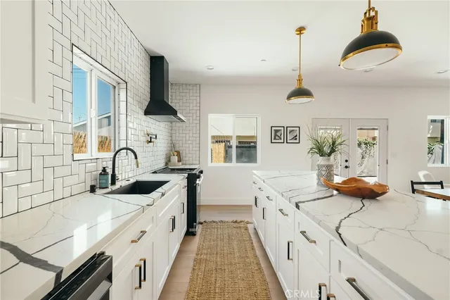 a kitchen with stainless steel appliances kitchen island granite countertop a stove a sink and a refrigerator