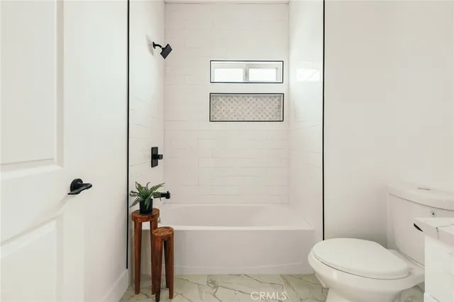 a bedroom with a bed two lamps and a table