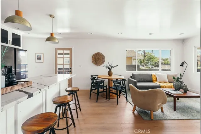 a kitchen with stainless steel appliances kitchen island granite countertop a stove a sink a dining table and chairs