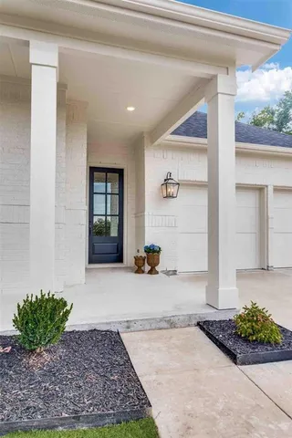 a view of a hallway with wooden floor and a couch