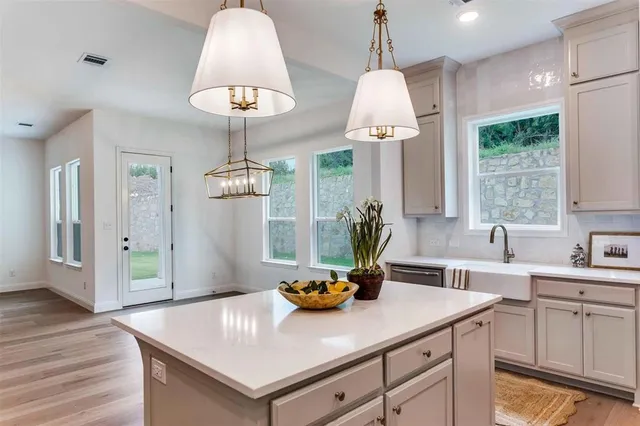 a kitchen with stainless steel appliances a table chairs and white cabinets