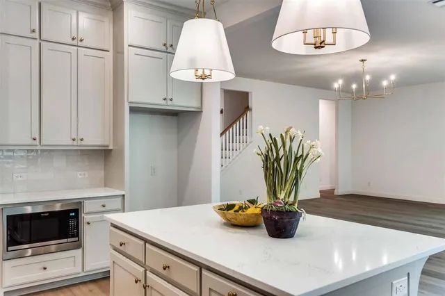 a kitchen with a sink a stove and white cabinets