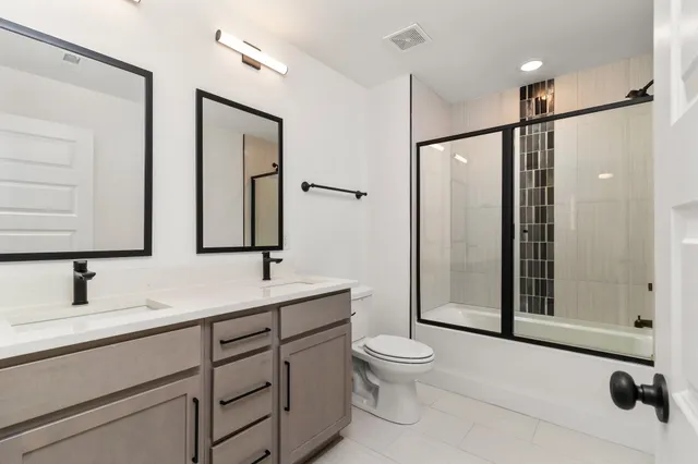 a bathroom with a toilet sink a mirror and shower