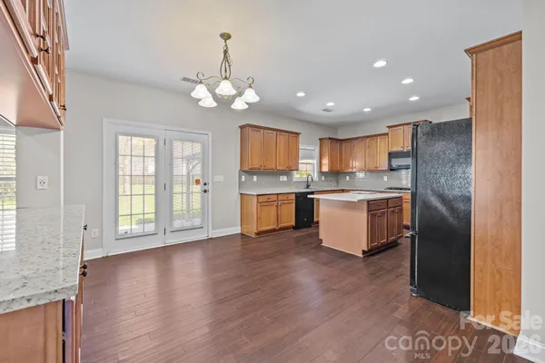 a large kitchen with granite countertop a large counter top space stainless steel appliances and a window