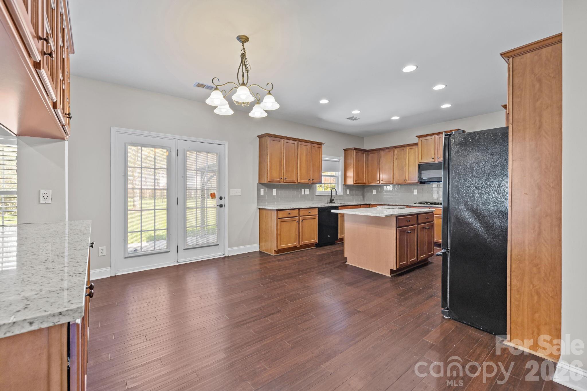 6226 Hermsley Road Charlotte, NC 28278 - Photo 12 of 47 a large kitchen with granite countertop a large counter top space stainless steel appliances and a window