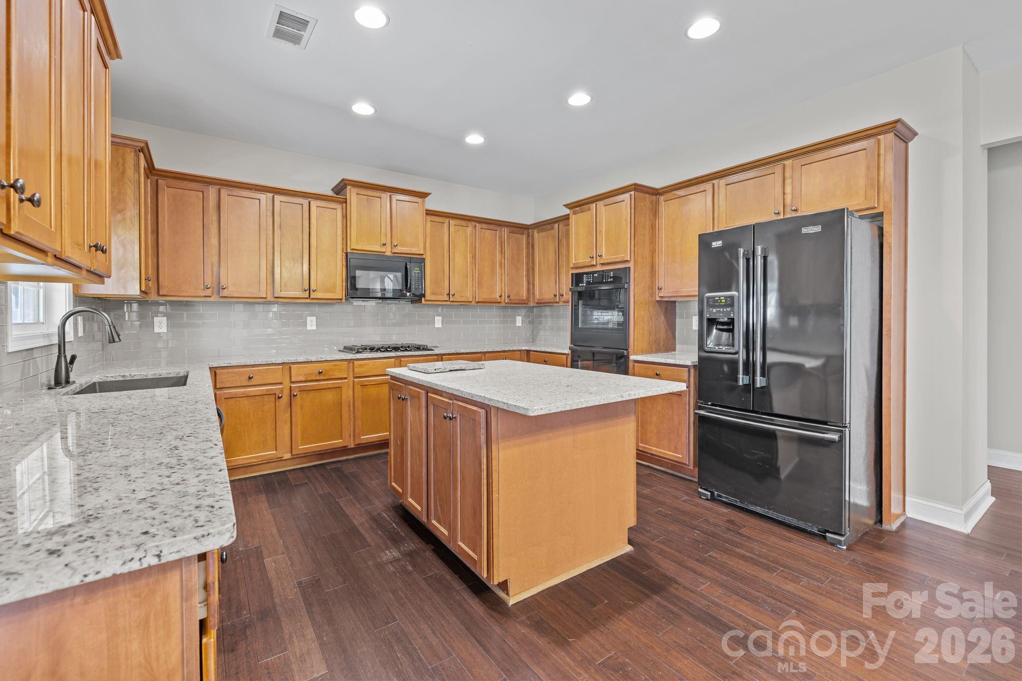 6226 Hermsley Road Charlotte, NC 28278 - Photo 14 of 47 a kitchen with stainless steel appliances granite countertop a sink stove and refrigerator