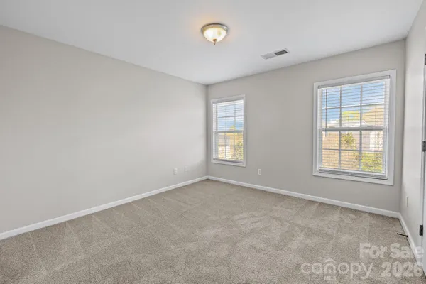 an empty room with windows and closet area