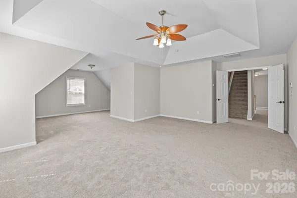 an empty room with a ceiling fan and window