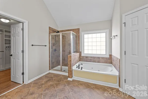 a spacious bathroom with a tub shower and window