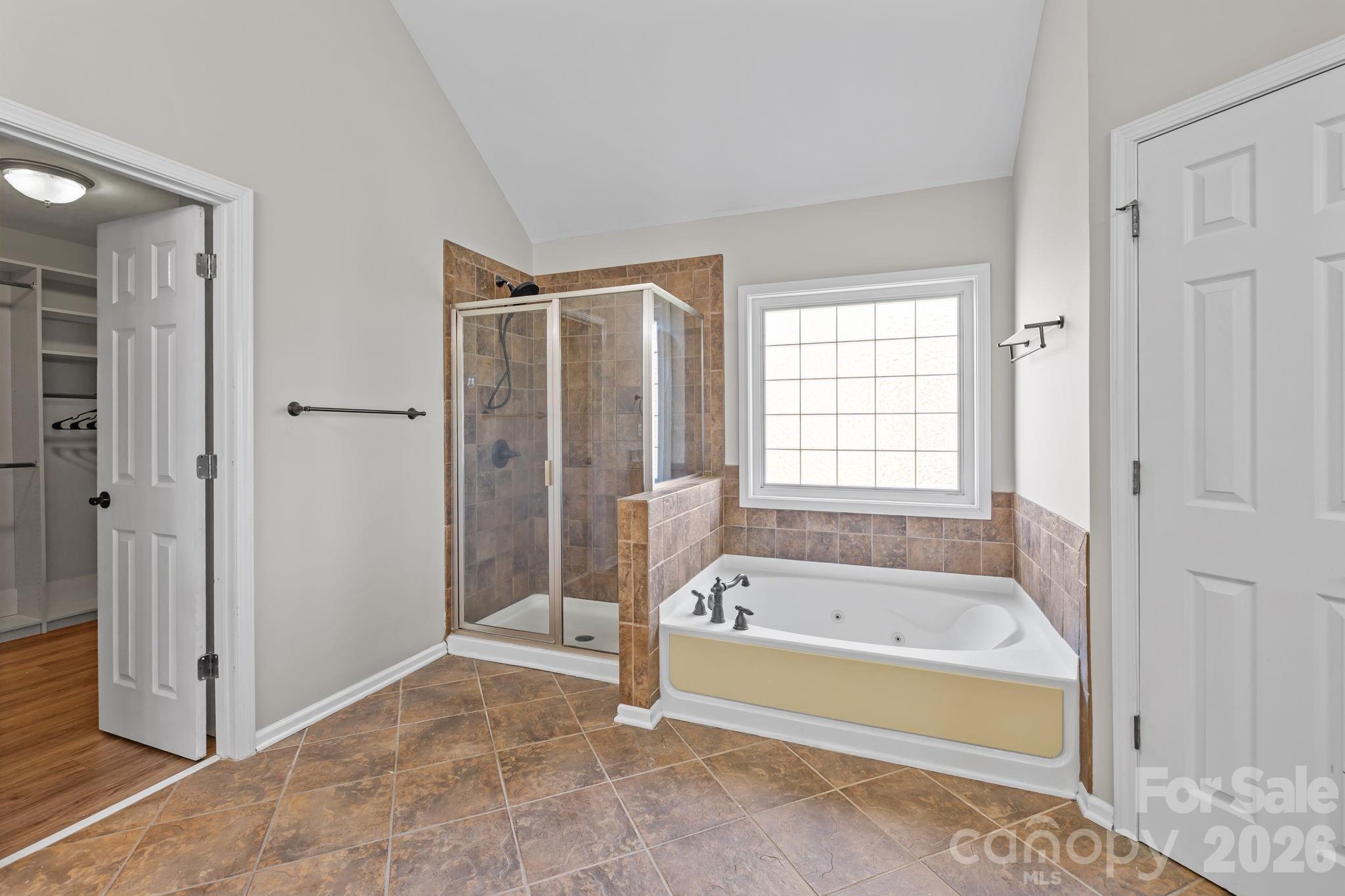 6226 Hermsley Road Charlotte, NC 28278 - Photo 32 of 47 a spacious bathroom with a tub shower and window