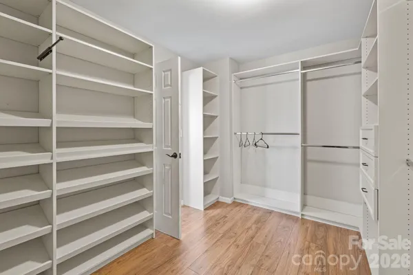 a view of walk in closet with empty racks