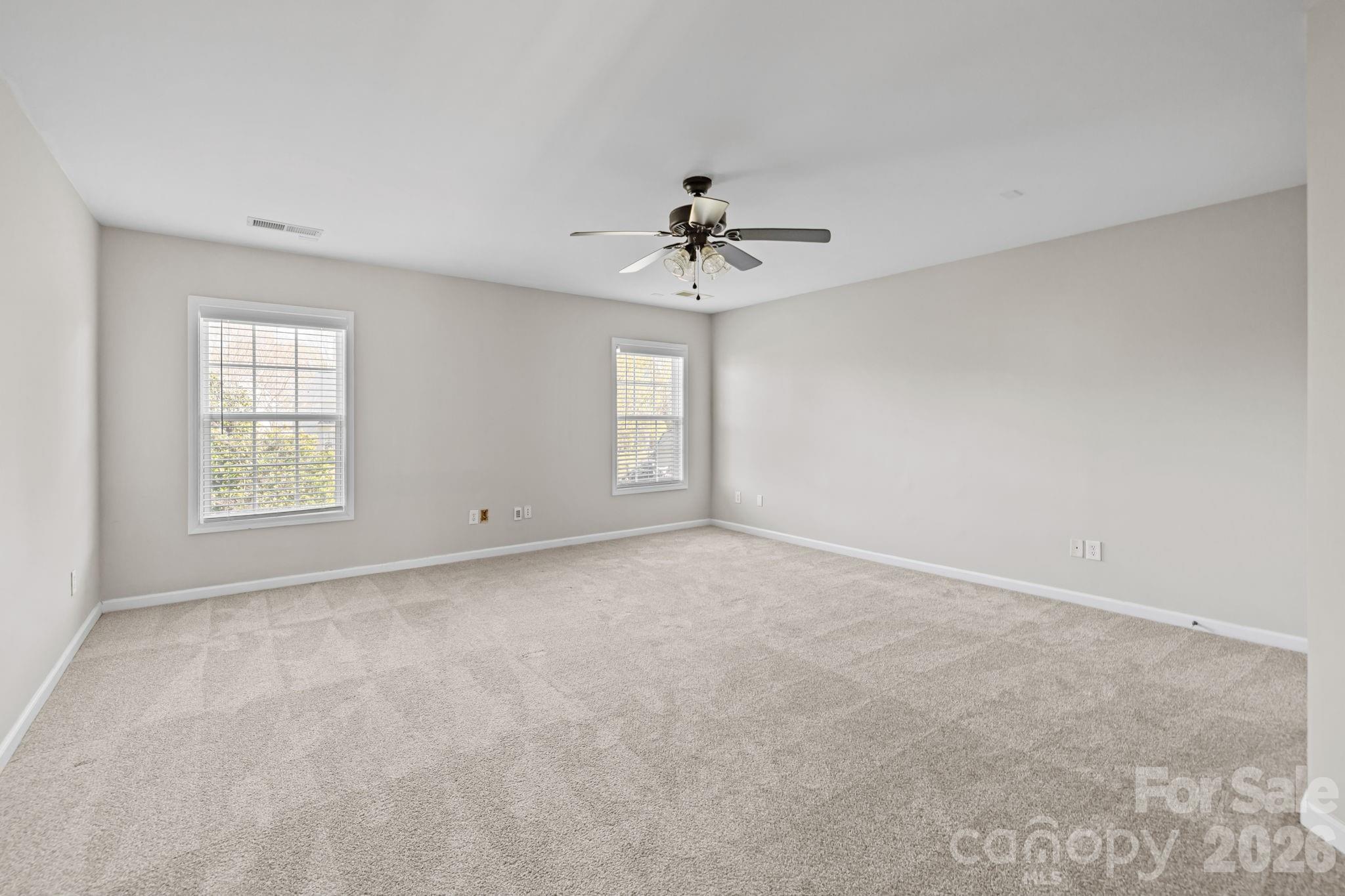 6226 Hermsley Road Charlotte, NC 28278 - Photo 35 of 47 an empty room with windows and ceiling fan