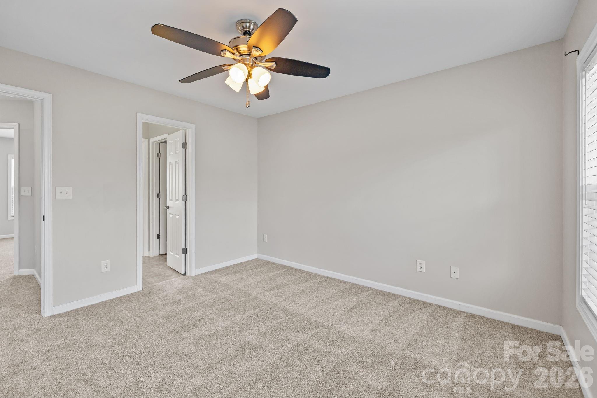 6226 Hermsley Road Charlotte, NC 28278 - Photo 38 of 47 an empty room with a chandelier fan and a window