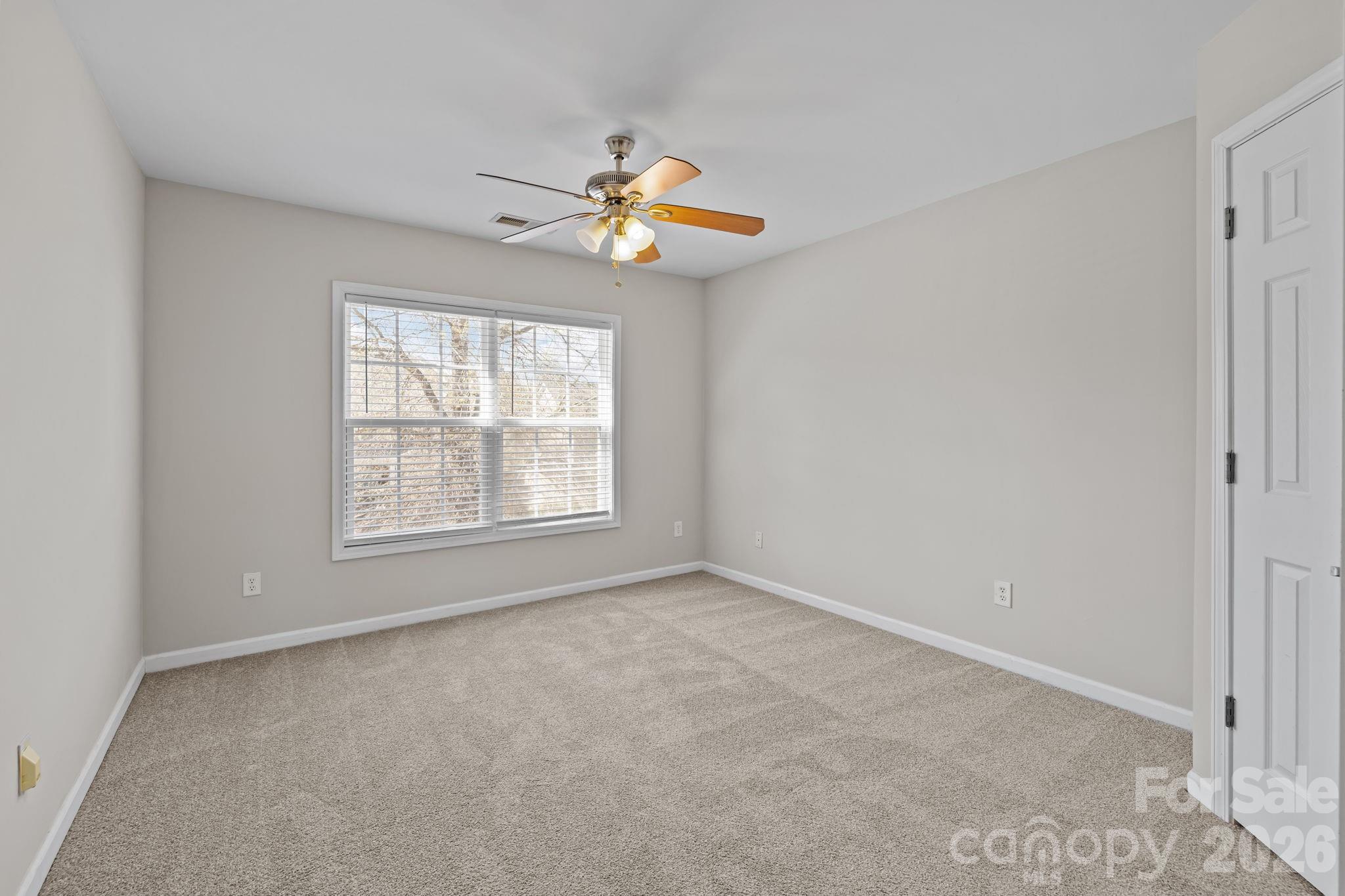 6226 Hermsley Road Charlotte, NC 28278 - Photo 40 of 47 an empty room with windows and chandelier fan