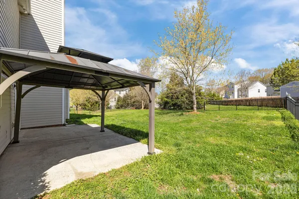 a view of a backyard with table and chairs under an umbrella