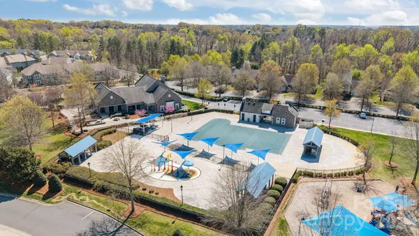 an aerial view of a house with swimming pool and outdoor seating
