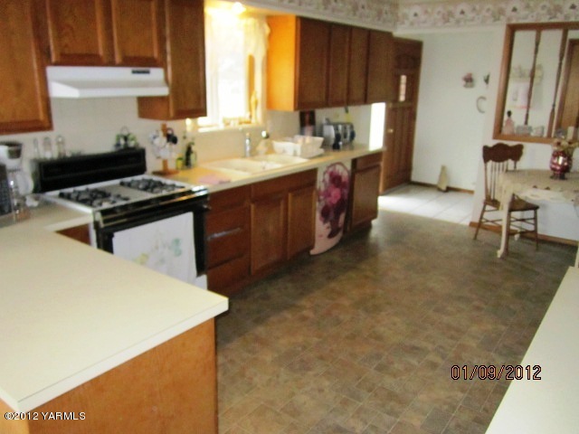 661 Swan Road Sunnyside, WA 98944 - Photo 4 of 6 a kitchen with a sink a stove and a refrigerator