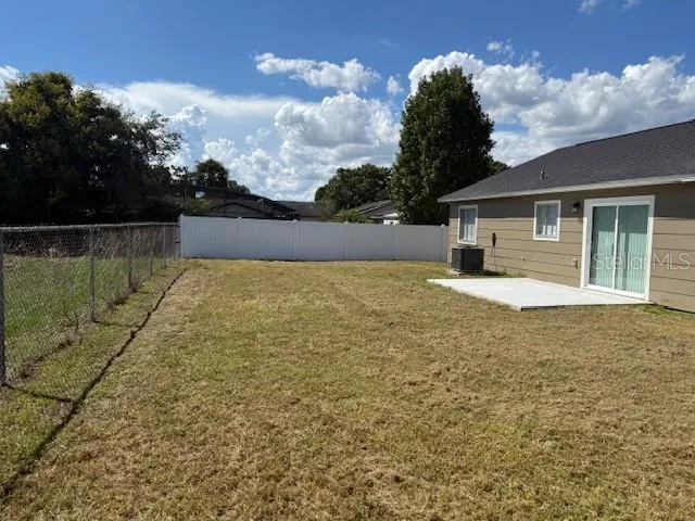 a view of a lake with a yard and large trees