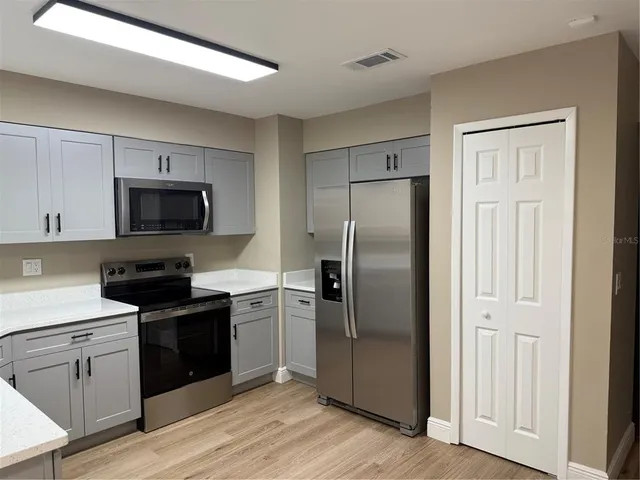 a kitchen with a refrigerator stove and microwave
