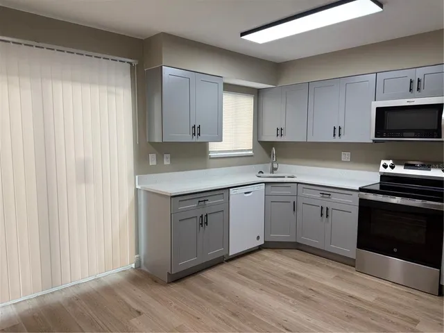 a kitchen with a sink cabinets and wooden floor