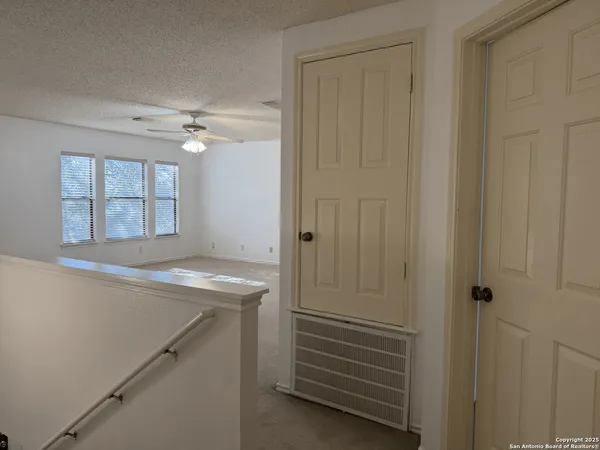 an empty room with a ceiling fan and a window