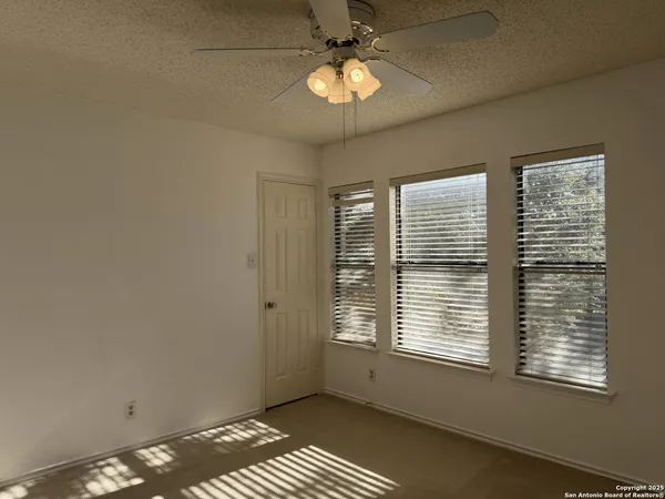 an empty room with a chandelier fan