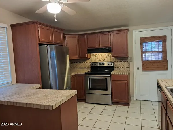 a kitchen with granite countertop a stove a refrigerator and a sink