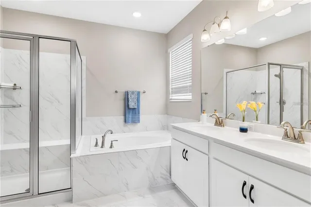 a bathroom with a tub a sink and mirror